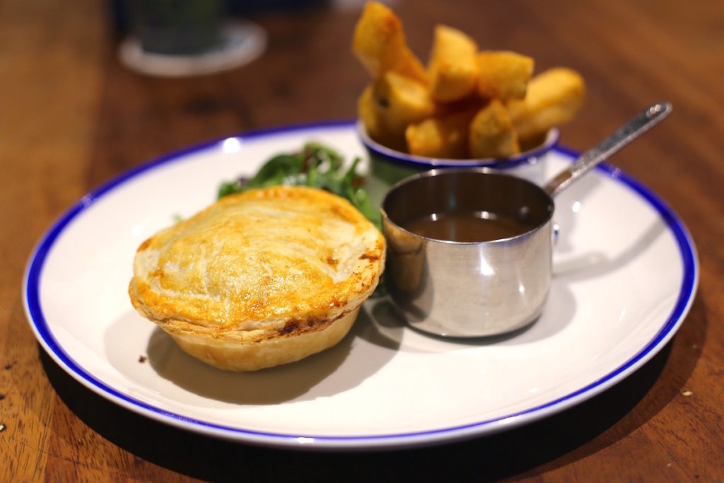 Pie and chunky chips with gravy and greens