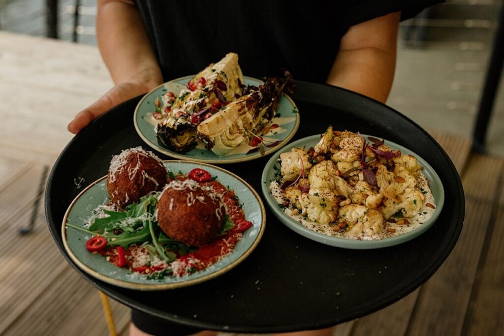 Server carrying small plates on tray