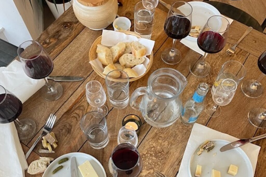 Rustic wooden table with cheese and red wine