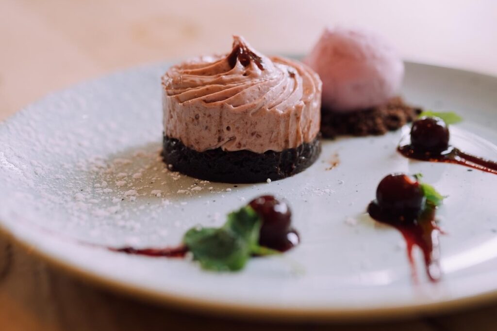 Cherry and chocolate cheesecake served with a scoop of cherry ice cream
